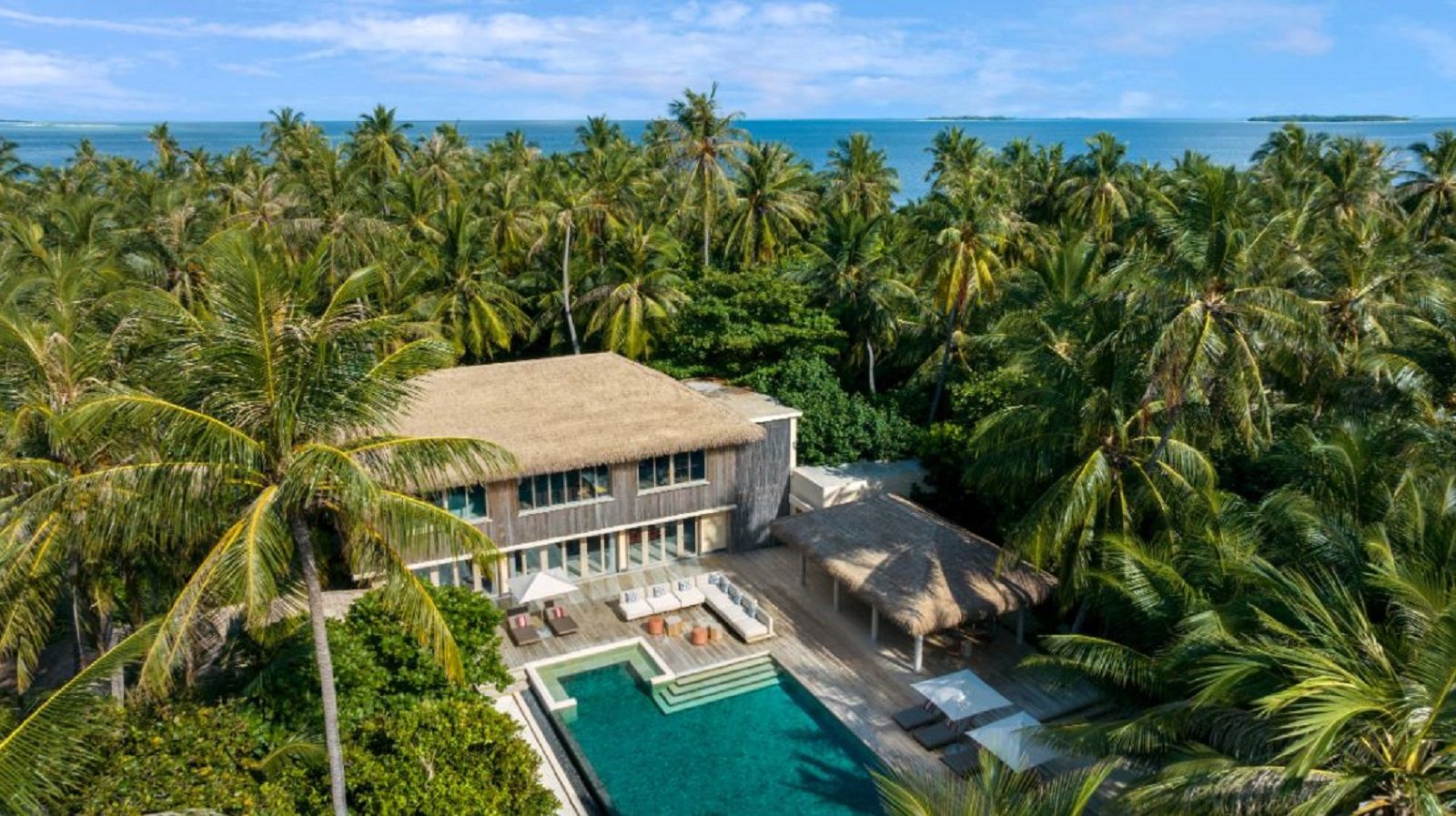 A House With A Pool And Palm Trees By It